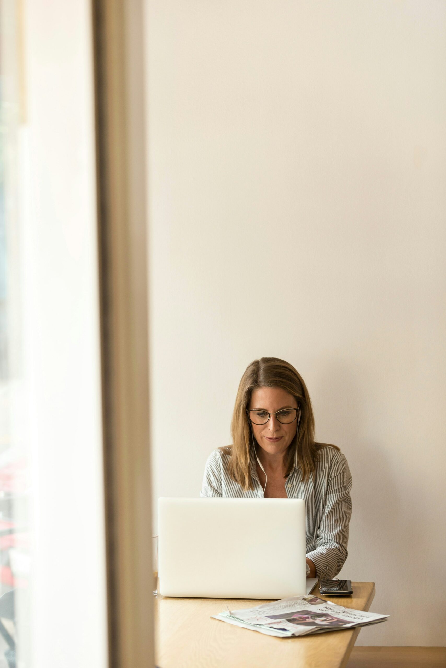 Frau arbeitet konzentriert am Laptop mit Büchern, steht für Weiterbildungen und Seminare bei Goldegg Training in Verlag, Lektorat, Korrektorat und Buchbranche, Online- und Präsenzkurse