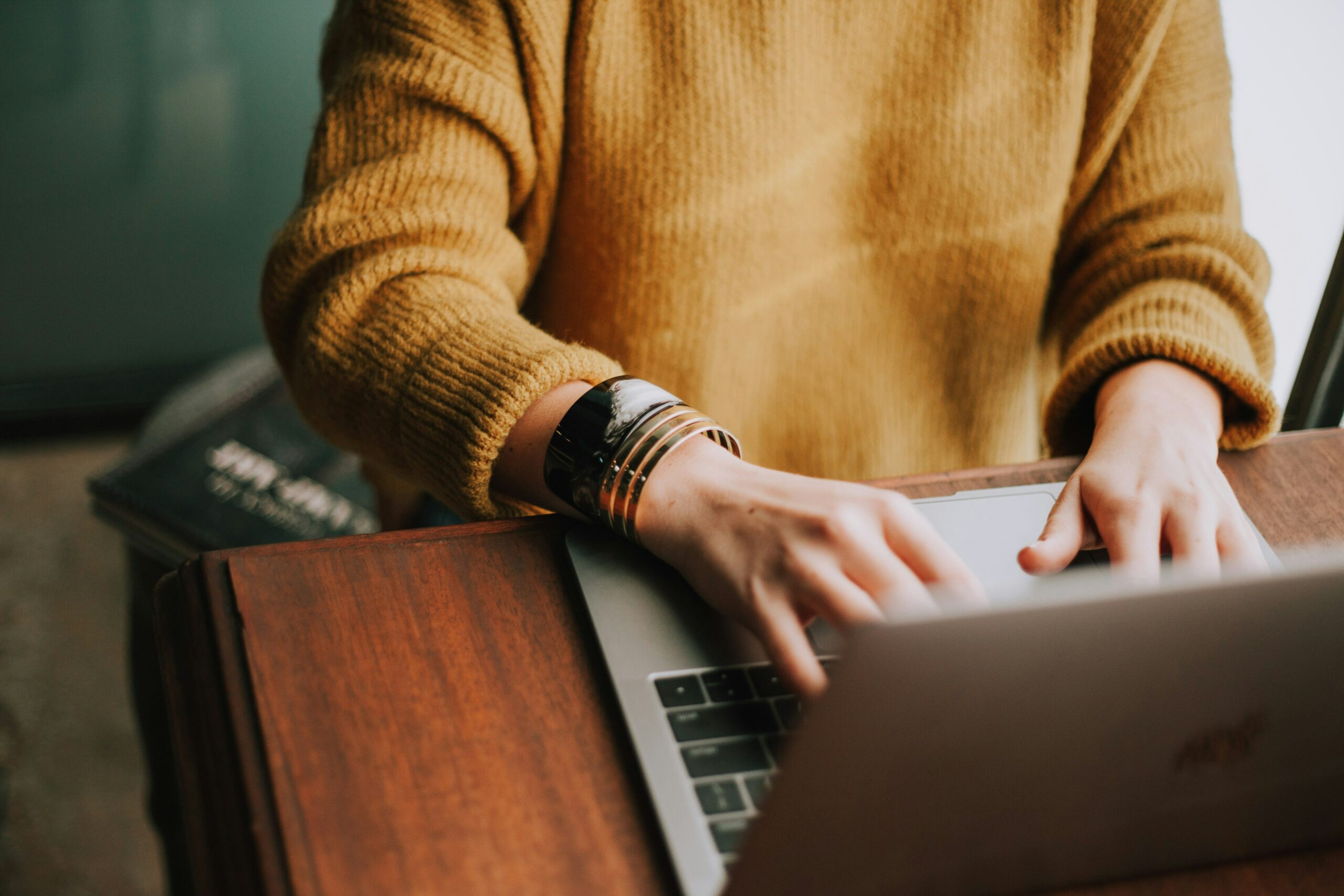 Teilnehmerin eines digitalen Infoabends des Goldegg Trainings tippt am Laptop, Online-Präsentation zu Lehrgängen und Weiterbildungskursen für berufliche Qualifikation in der Buchbranche